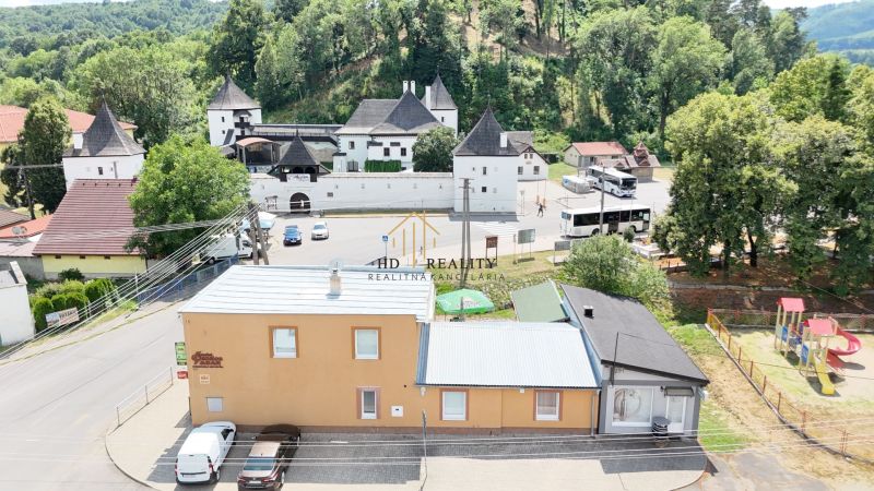 Commercial premises in Divín with a view of historical architecture and greenery.