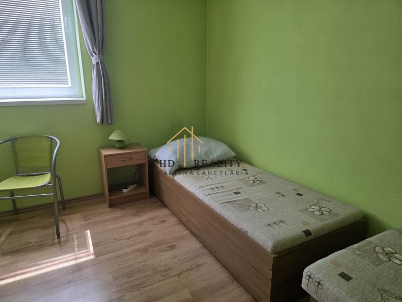 A room with a bed, a table, and a floor with a wooden decor in commercial premises.