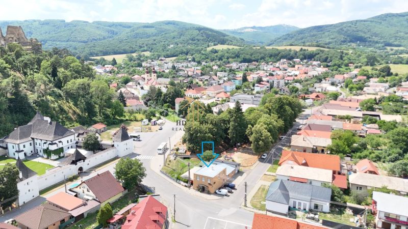 A view of commercial premises in Divín, surrounded by greenery and neighboring buildings.