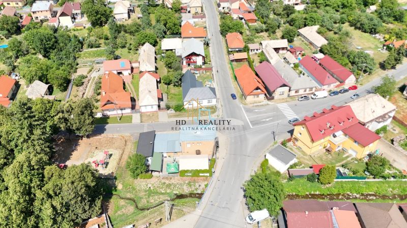 Aerial view of houses and roads in the village of Divín surrounded by greenery.