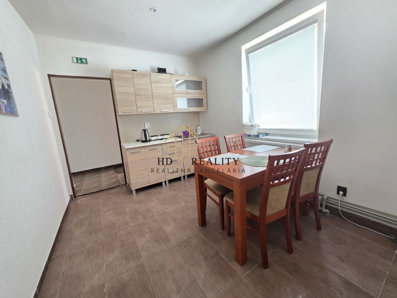 A kitchen corner with a wooden decor floor and a dining table in commercial premises.
