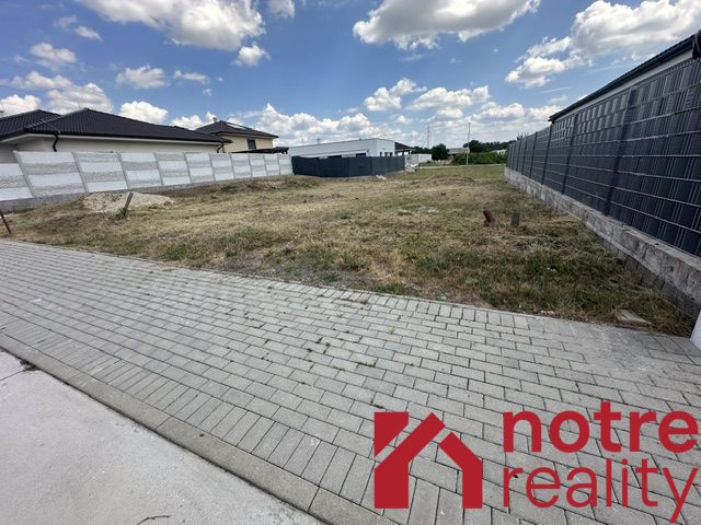A residential plot in Lučenec offers a spacious grassy area next to the paving.