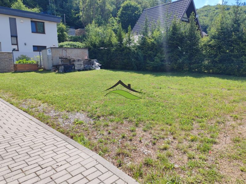A grassy plot in the Recreational Lands of Valkov in Bžany, surrounded by trees and houses.