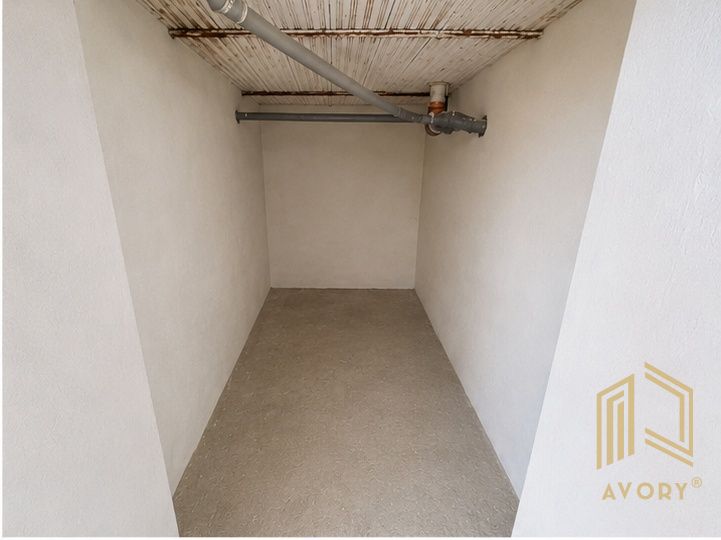 Narrow interior of a cabin with light walls and concrete floor.