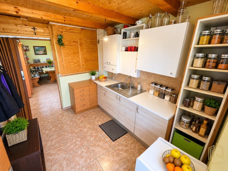 A kitchen in a cabin with a wood-patterned floor, full of storage shelves and elements.