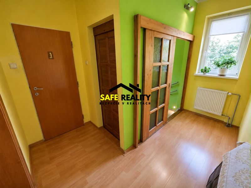 In the family house, there are yellow walls and a floor with a wooden design.