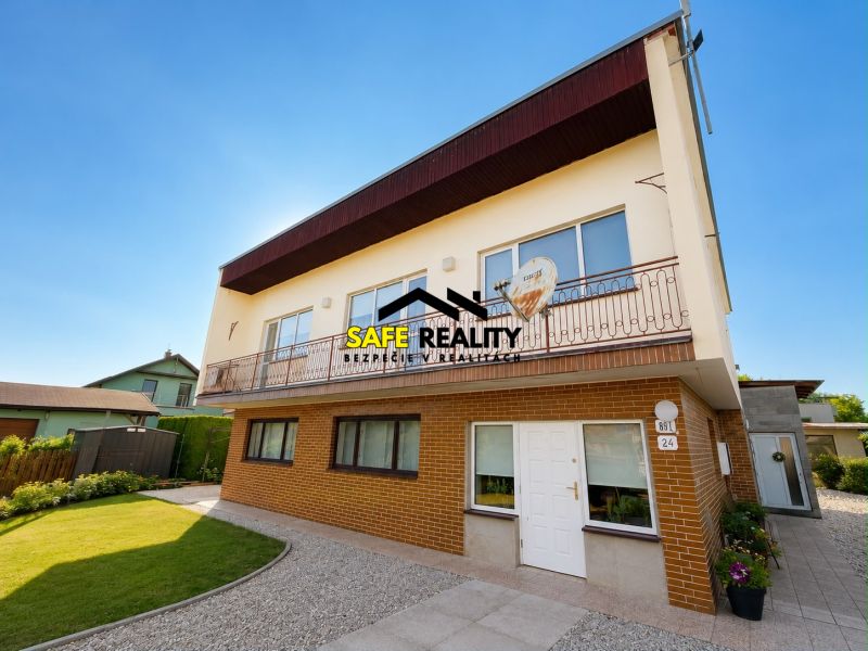 A family house in Bytča with a garden, two floors, brick facade, and a balcony.