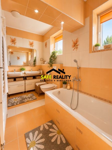 A bathroom with orange and white tiles, a double sink, and a bathtub in a family house.