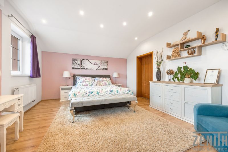 Bright bedroom in a family house with colorful decorative elements and a wooden-patterned floor.