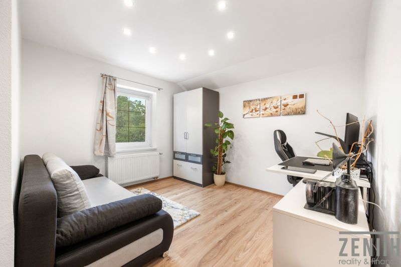 Home office with a sofa, wardrobe, desk, and wooden decor flooring.