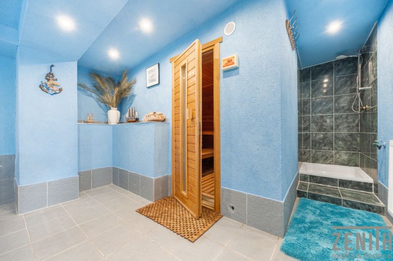Blue sauna and shower in a family house, decorative elements and ornamental vases in the corner.
