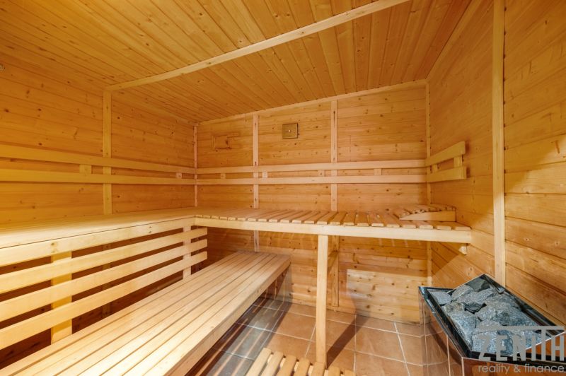 A sauna with wooden benches and a heating device in a family house.