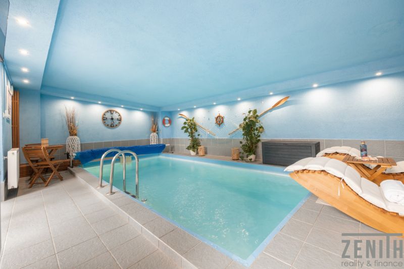 An indoor swimming pool in a family house with nautical-themed decorations.
