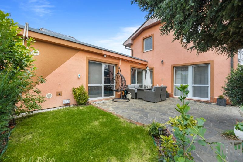 A family house in Bernolákovo with a terrace, garden furniture, and a view of a well-maintained lawn.