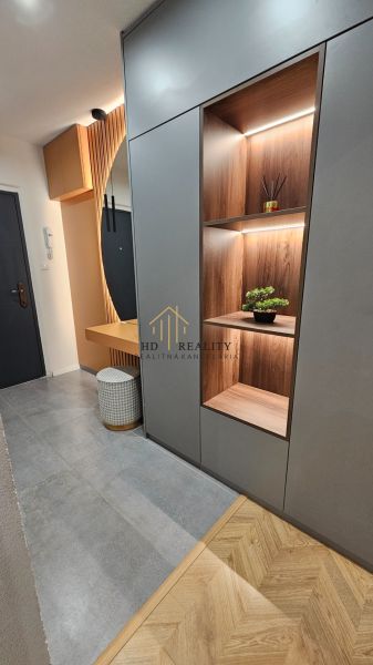 Entrance hall in a 2-room apartment with shelves and wooden decor flooring.