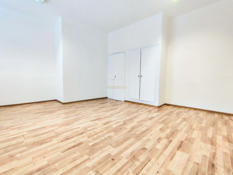 A bright room in offices with white walls and a floor with a wooden decor.