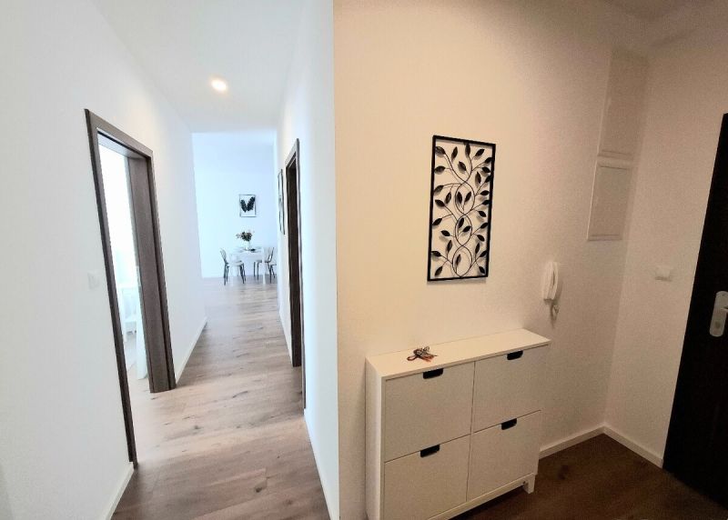 A hallway with a wall with decoration and a floor with a wooden decor in a 2-room apartment.