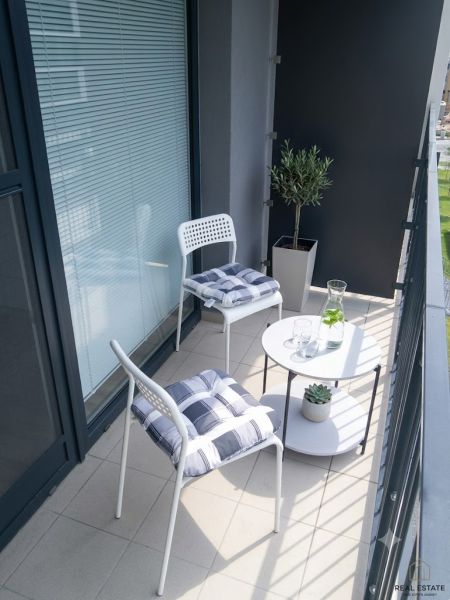 Balcony in a studio apartment on Zuzany Chalupovej Street in Bratislava - Petržalka with white furniture.