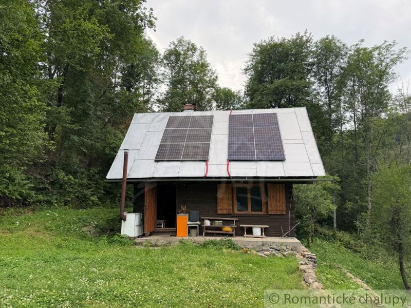 A family house in Kokava nad Rimavicou with wooden shutters and solar panels on the roof.