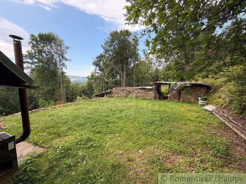 The garden of a family house in Kokava nad Rimavicou with a lawn and a view of the forests.