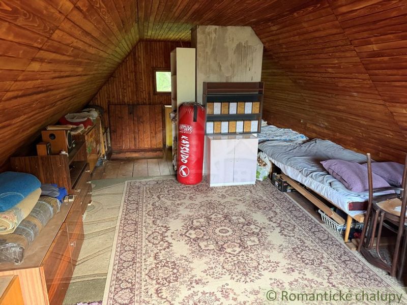 Attic room with wooden decor, a bed, and a punching bag in a family house.