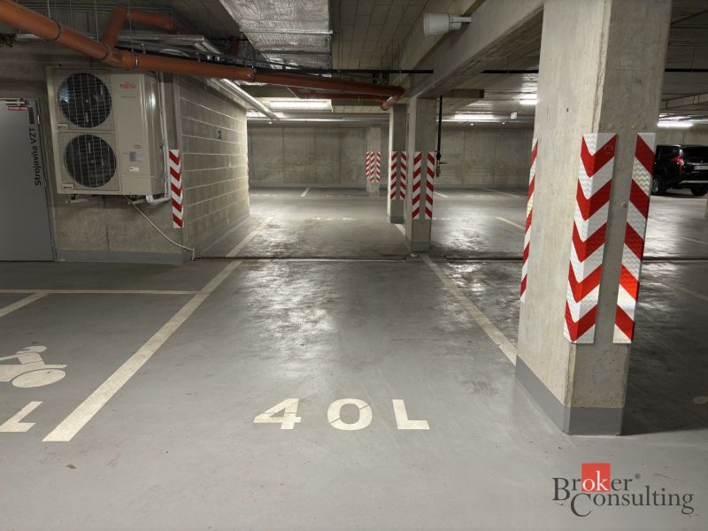 Underground garages with marked spaces, concrete pillars, and air conditioning.