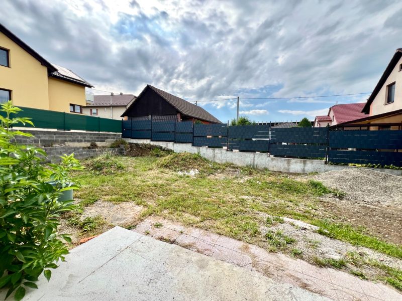 A family house in Ľubotín with a fenced plot, grassy area, and neighboring houses.