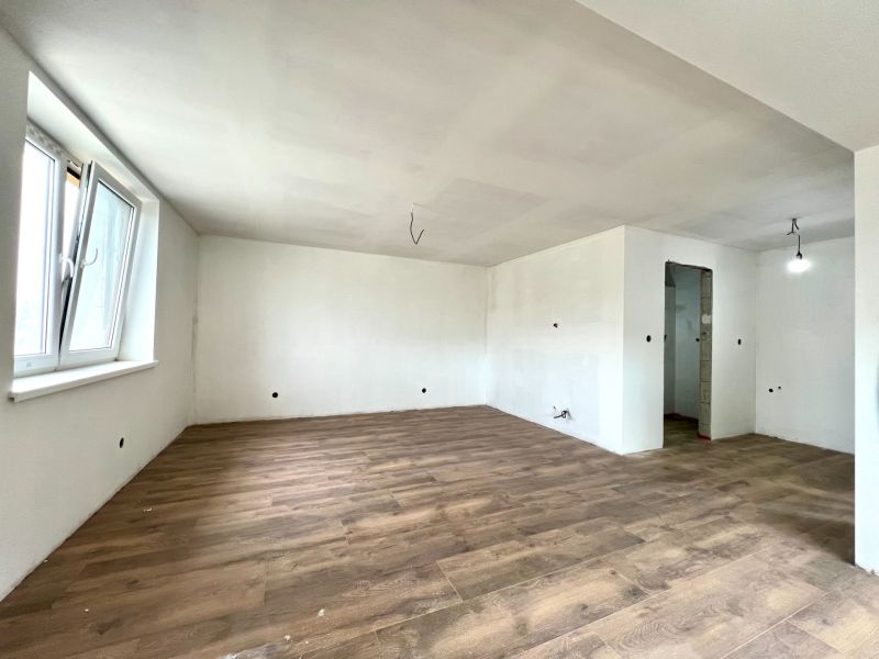 A spacious room in a family house with a wooden decor floor.