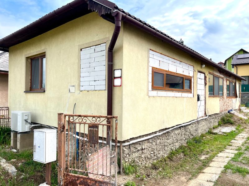 A family house in Ľubotín with a plastered facade and tiled finishes around the windows.