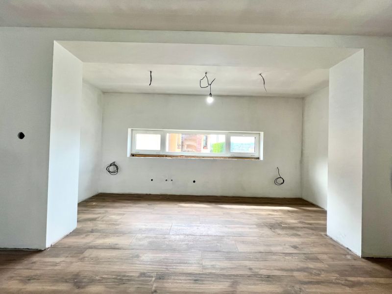 Interior of a family house with a wooden decor floor and preparation for electrical installation.