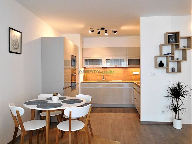 Modern kitchen and dining area in a 2-room apartment with a wooden decor floor.