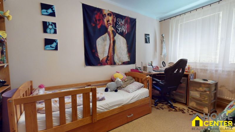 Children's room in a 3-room apartment with a bed, decorations, and a desk.