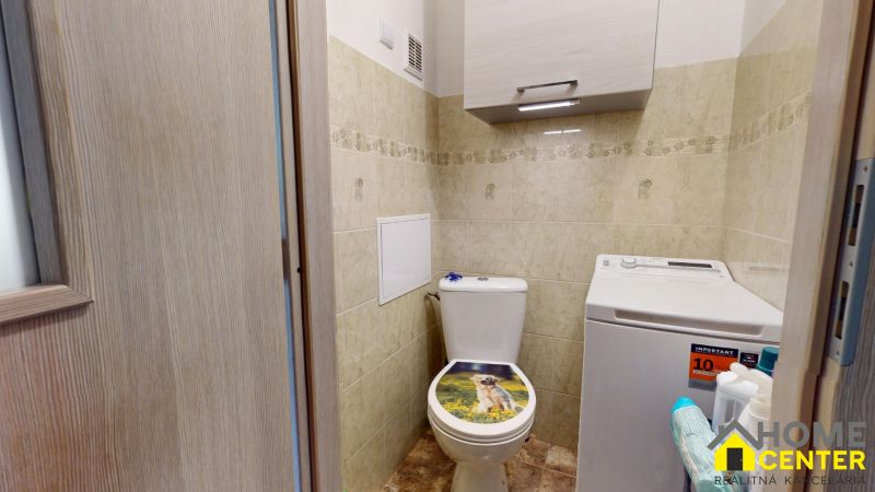 Bathroom in a 3-room apartment with a washing machine and toilet, decorated with tiles.