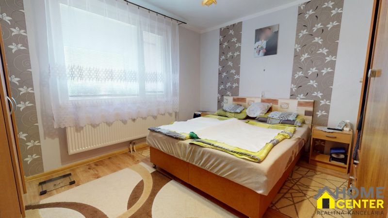 Bedroom in a 3-room apartment with a wooden decor floor, light and decorative walls.