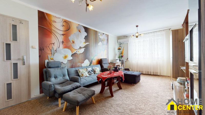 Living room in a 3-room apartment with a striking floral wallpaper and comfortable seating.