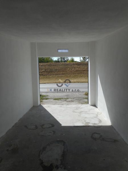A garage with white walls and a concrete floor overlooking Ľudovíta Stárka in Trenčín.