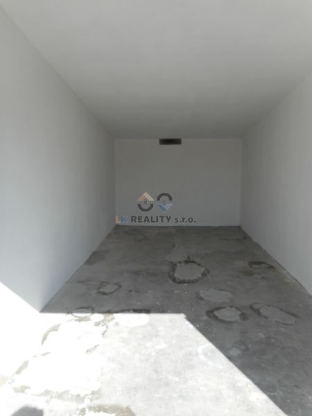 Parking garage in Trenčín on Ľudovíta Stárka with a concrete floor and white walls.