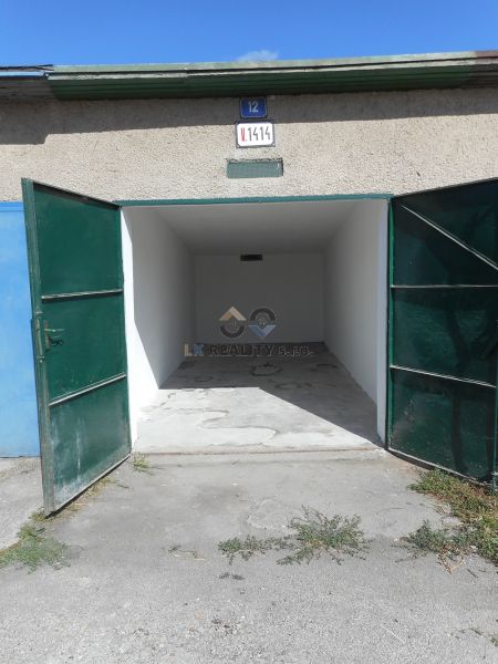 Open garages on Ľudovíta Stárka Street in Trenčín with concrete floors and green doors.