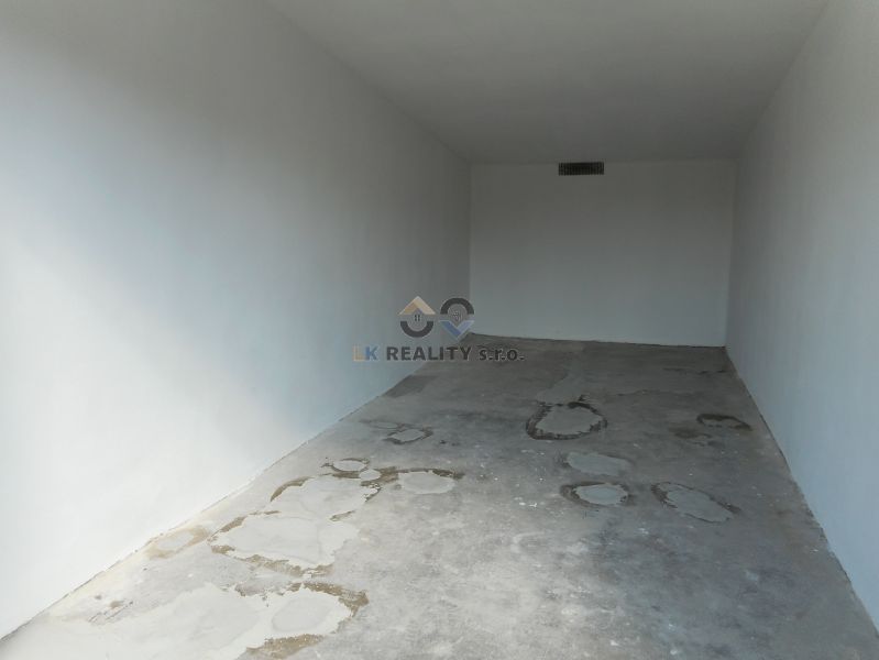 An empty space with white walls and a concrete floor. Garages in Trenčín on Ľudovíta Stárka.
