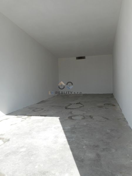 A view into an empty space with a concrete floor in a garage.