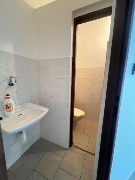 Bathroom manufacturing spaces with tiles and a sink next to the toilet.