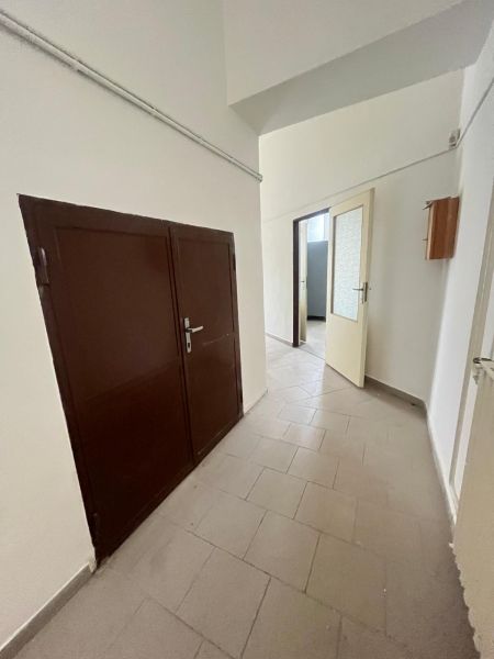 A corridor in manufacturing premises with a gray floor and double doors.