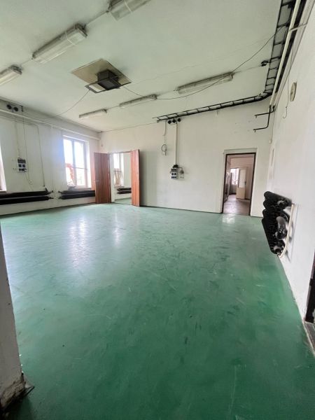 Production facilities with green flooring and white walls with lighting.