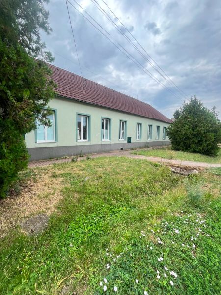 Production facilities in Diakovce with green lawns and a blue facade under a cloudy sky.
