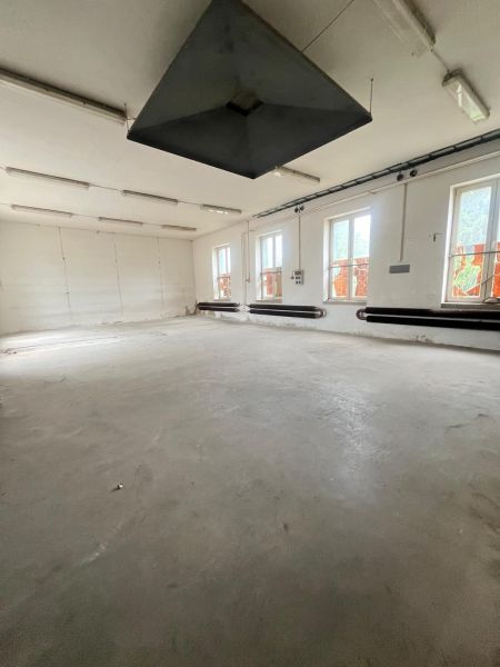 Production spaces with a minimalist interior, white walls, and gray floor.