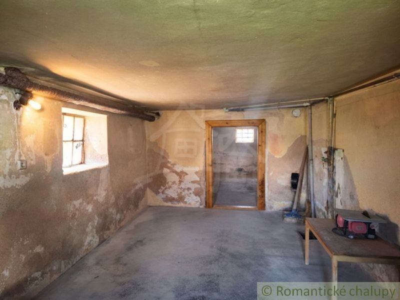 The basement of a family house in Ružiná with a concrete floor and simple furniture.