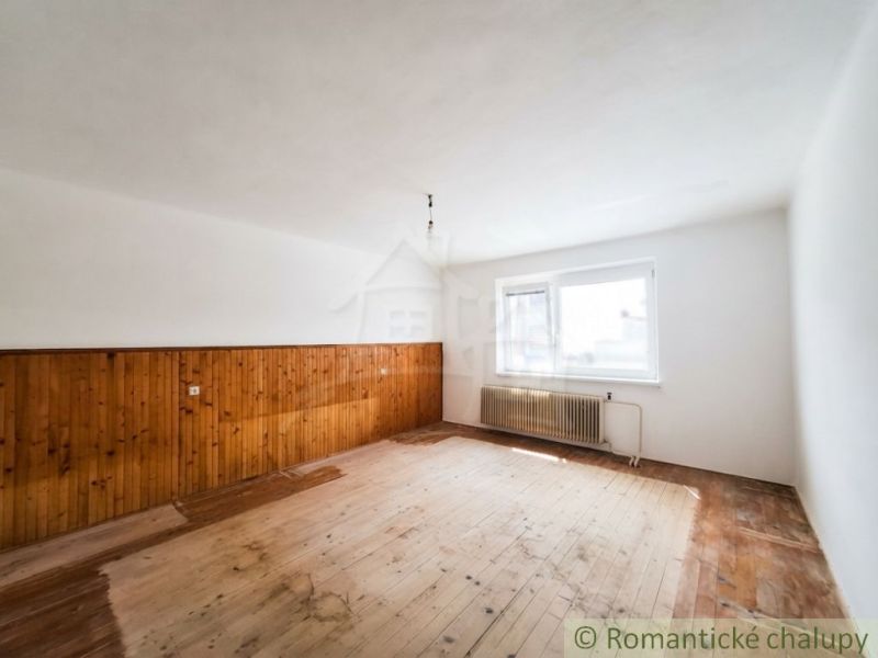 A room with a wood-patterned floor in a family house, walls made of wooden panels.