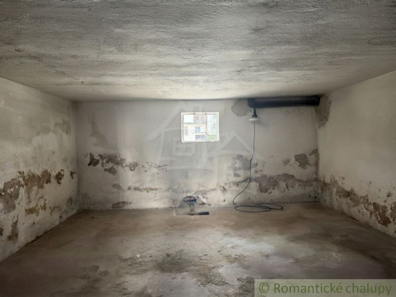 A room in a family house with old plaster and a smaller window.