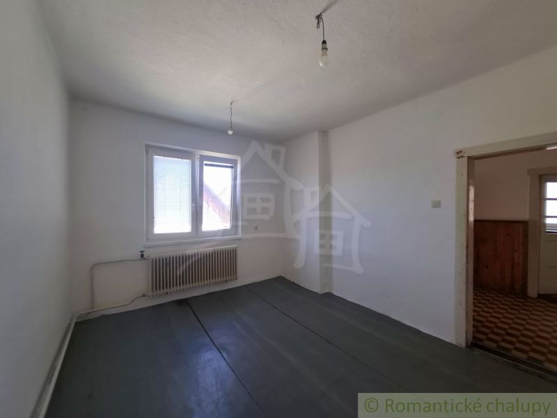 A room with a wooden decor floor and a radiator in a family house.