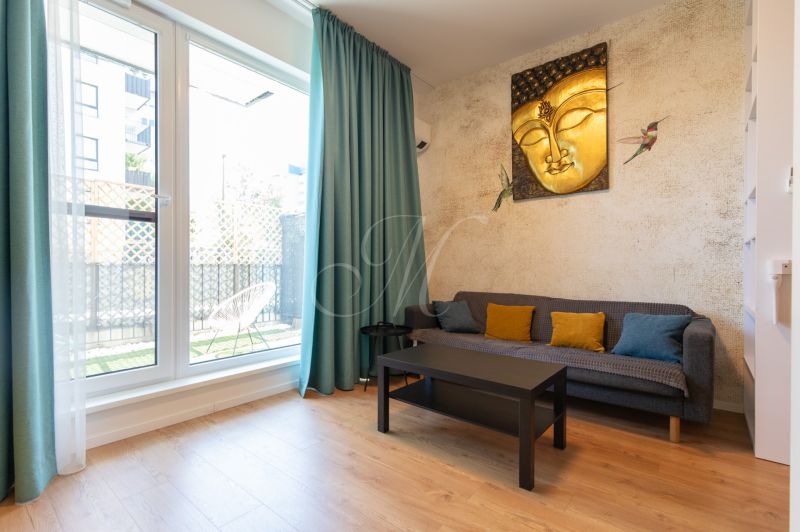 1-bedroom apartment with a wooden decor floor, a sofa, and a Buddha painting on the wall.